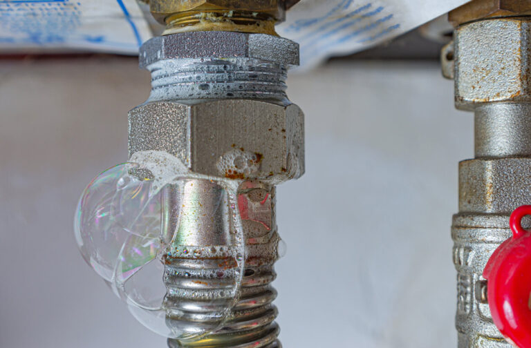 Gas line fitting showing soap bubbles, indicating a potential gas leak that needs urgent repair.