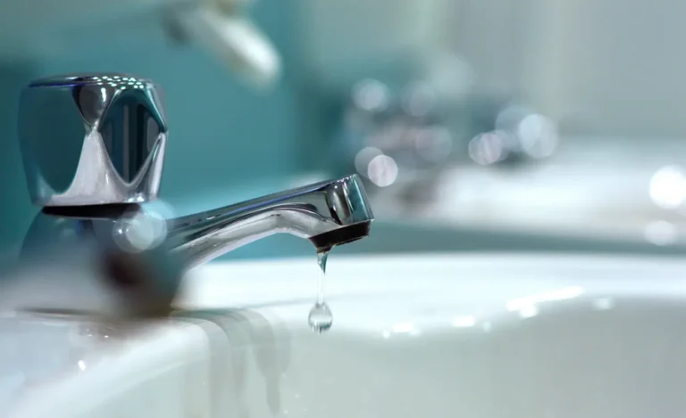 Close-up of a dripping chrome faucet representing urgent plumbing repair and risks of ignoring small leaks in Texas homes.
