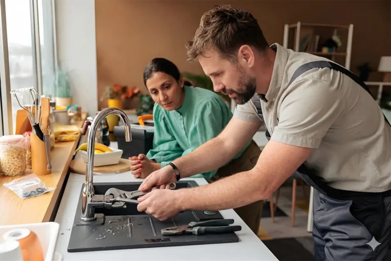 Professional plumber repairing a kitchen faucet in a Greater Houston home.