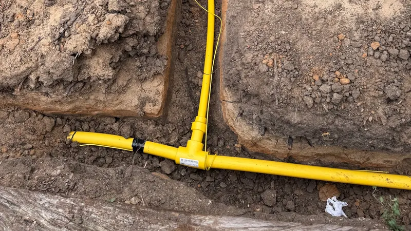 Yellow gas piping installed in an excavated trench