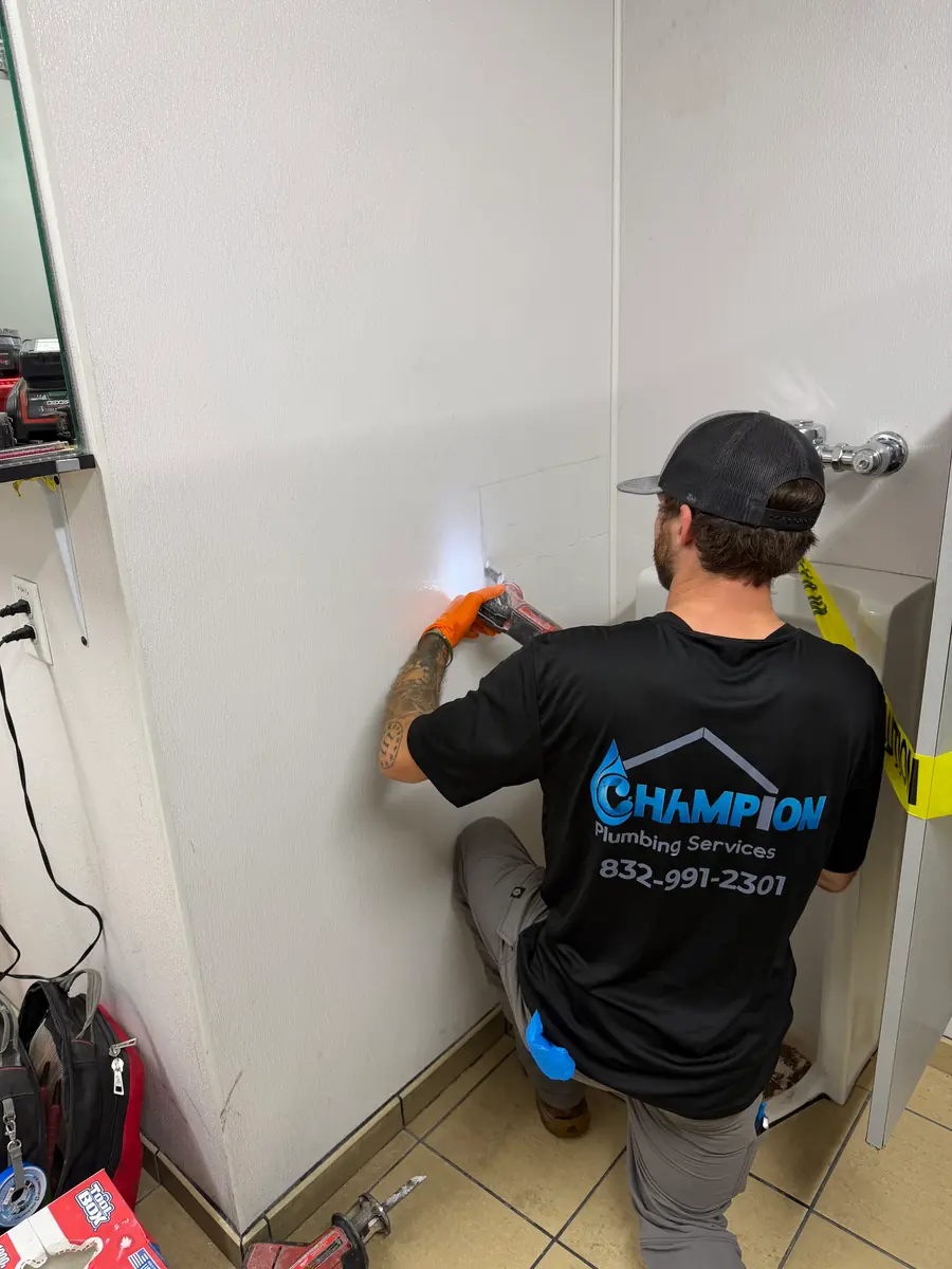 Champion plumbing technician working on an in-wall water line